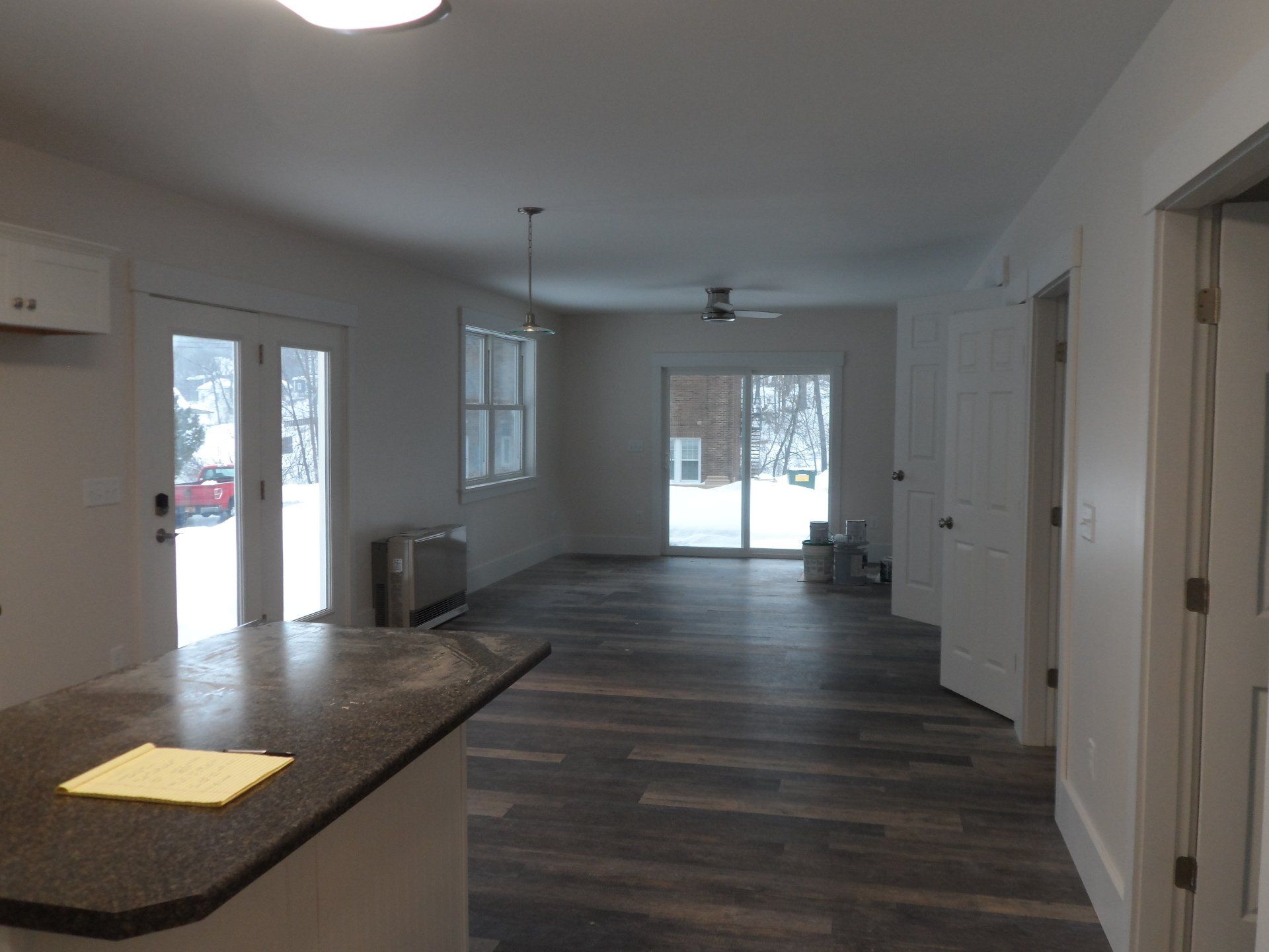 A kitchen with a sliding glass door and a ceiling fan