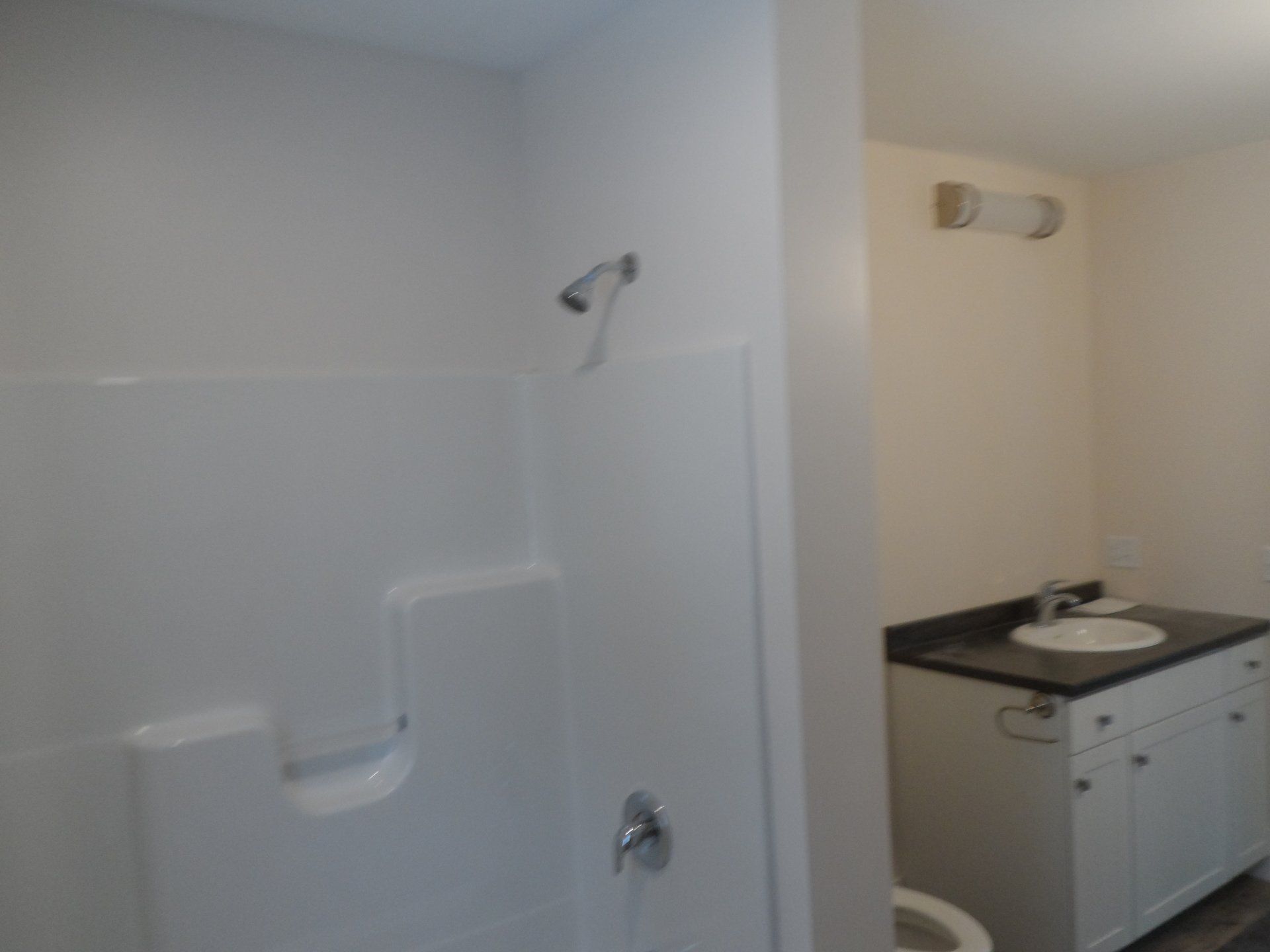 A bathroom with a toilet a sink and a shower