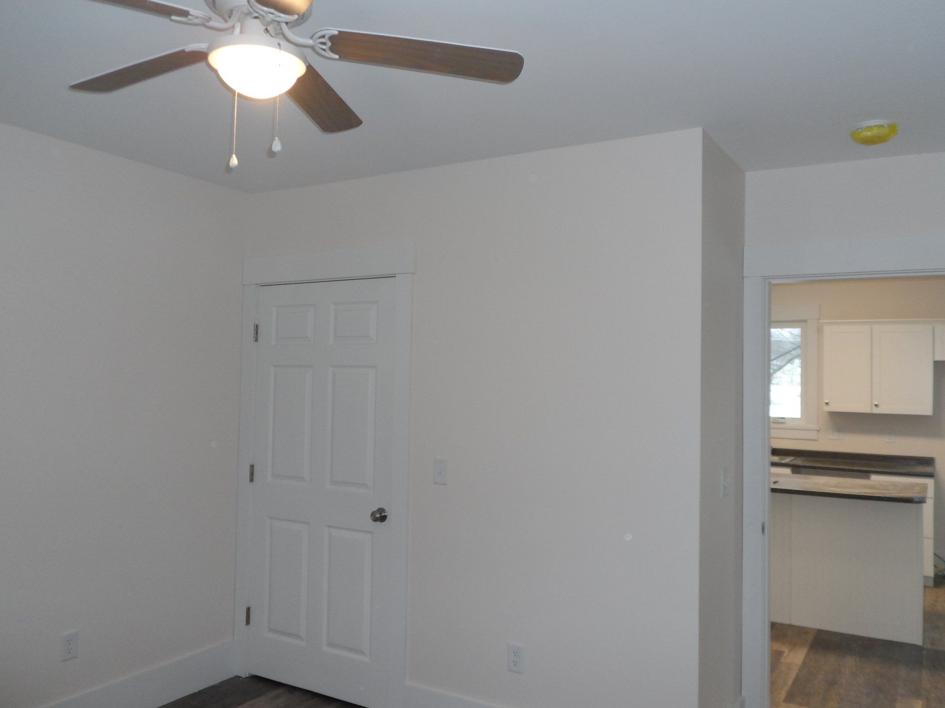 An empty room with a ceiling fan and a light