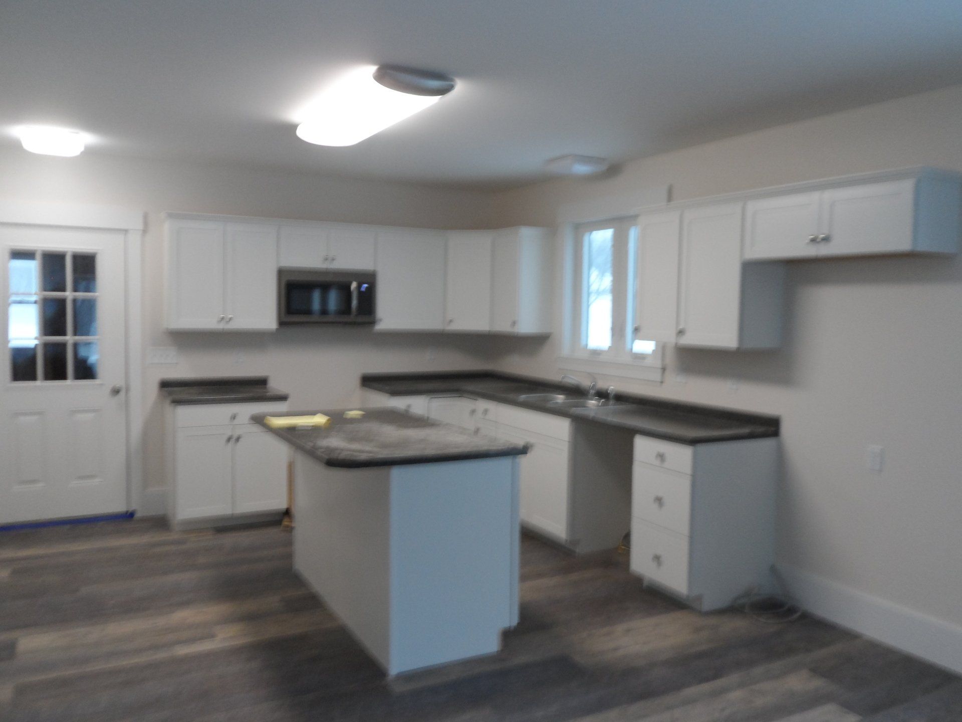 A kitchen with white cabinets and granite counter tops