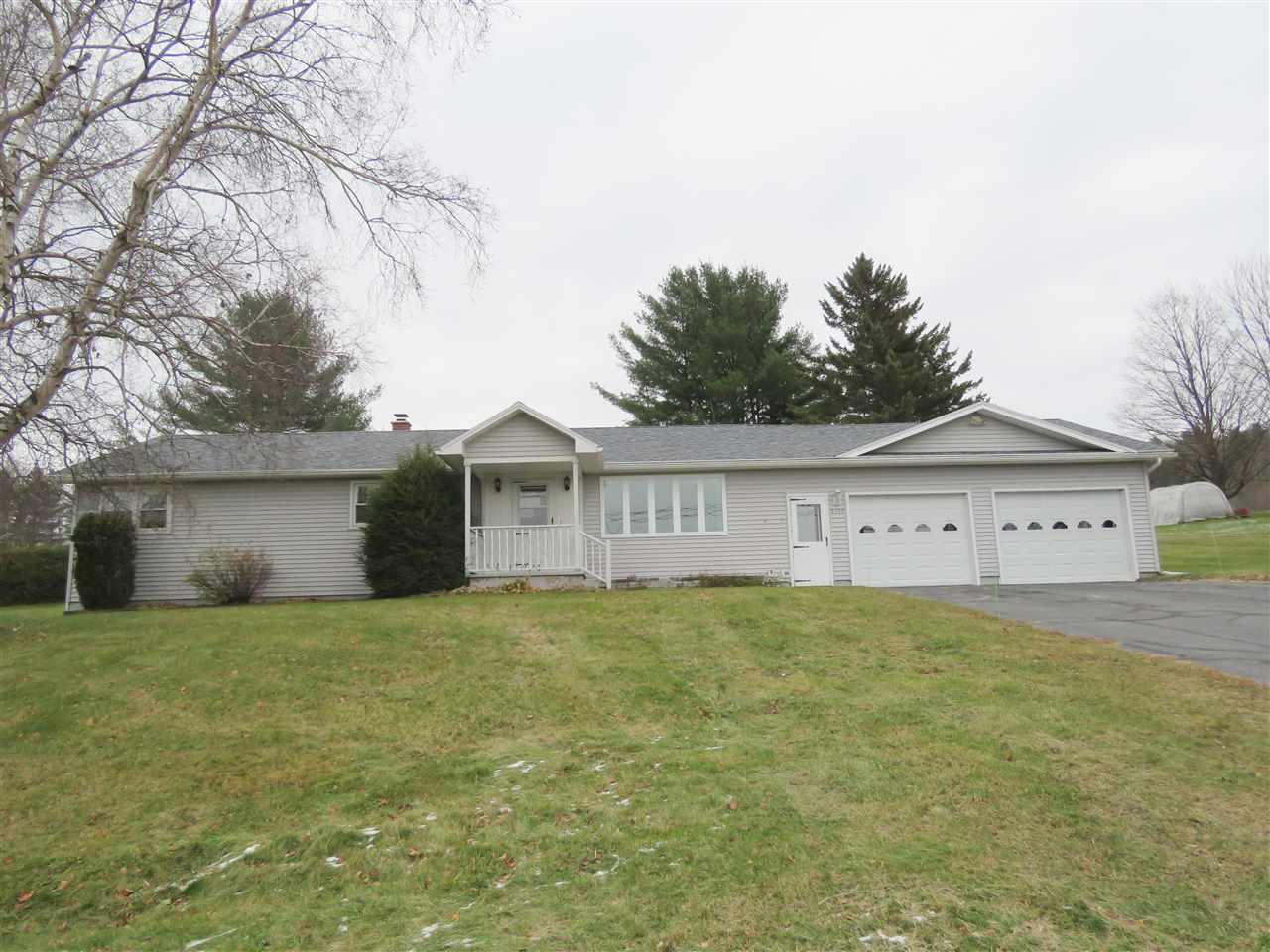 Ranch-style house with gray siding, two-car garage, and a small front yard with brown grass.