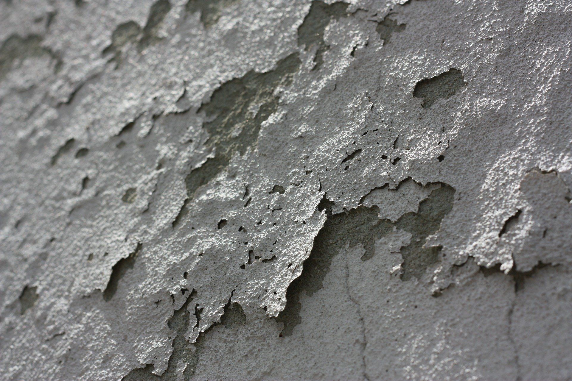 white cracked paint flaking off of a wall