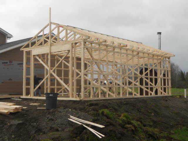 A large wooden structure is being built in a field