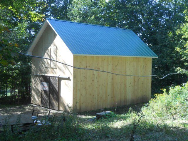 A small wooden building with a green roof