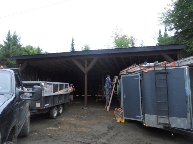 A man standing on a ladder next to a dump truck