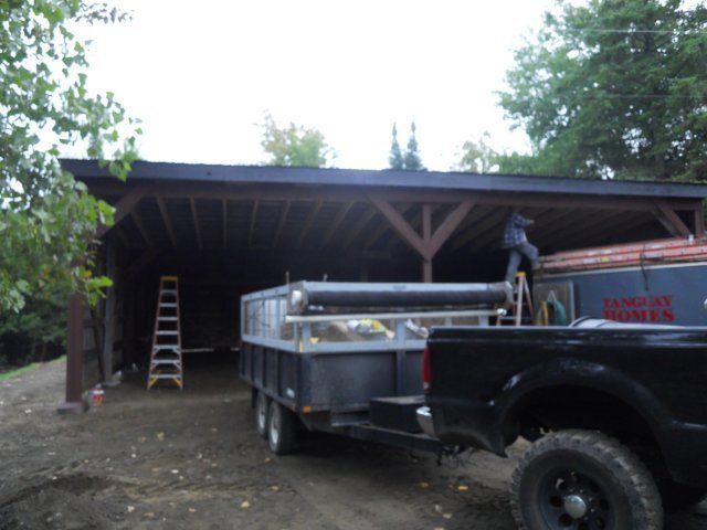 A black truck is parked in front of a building that says lumber miller