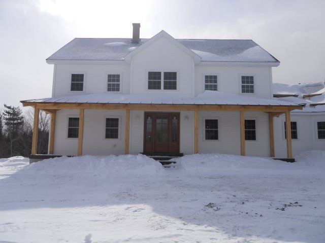 A white  house being sold in Northern Vermont