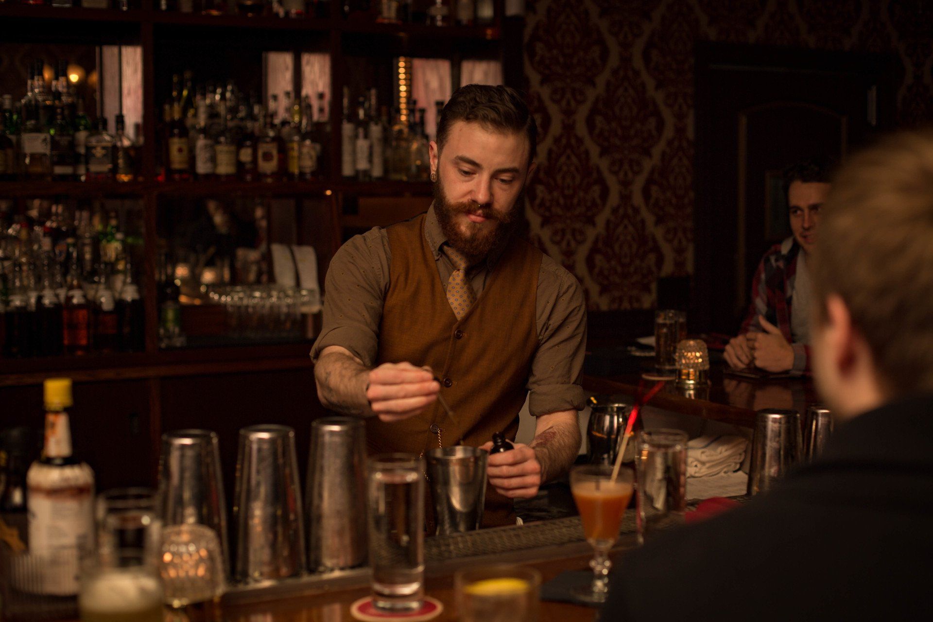 bartender preparing classic cocktails behind bar