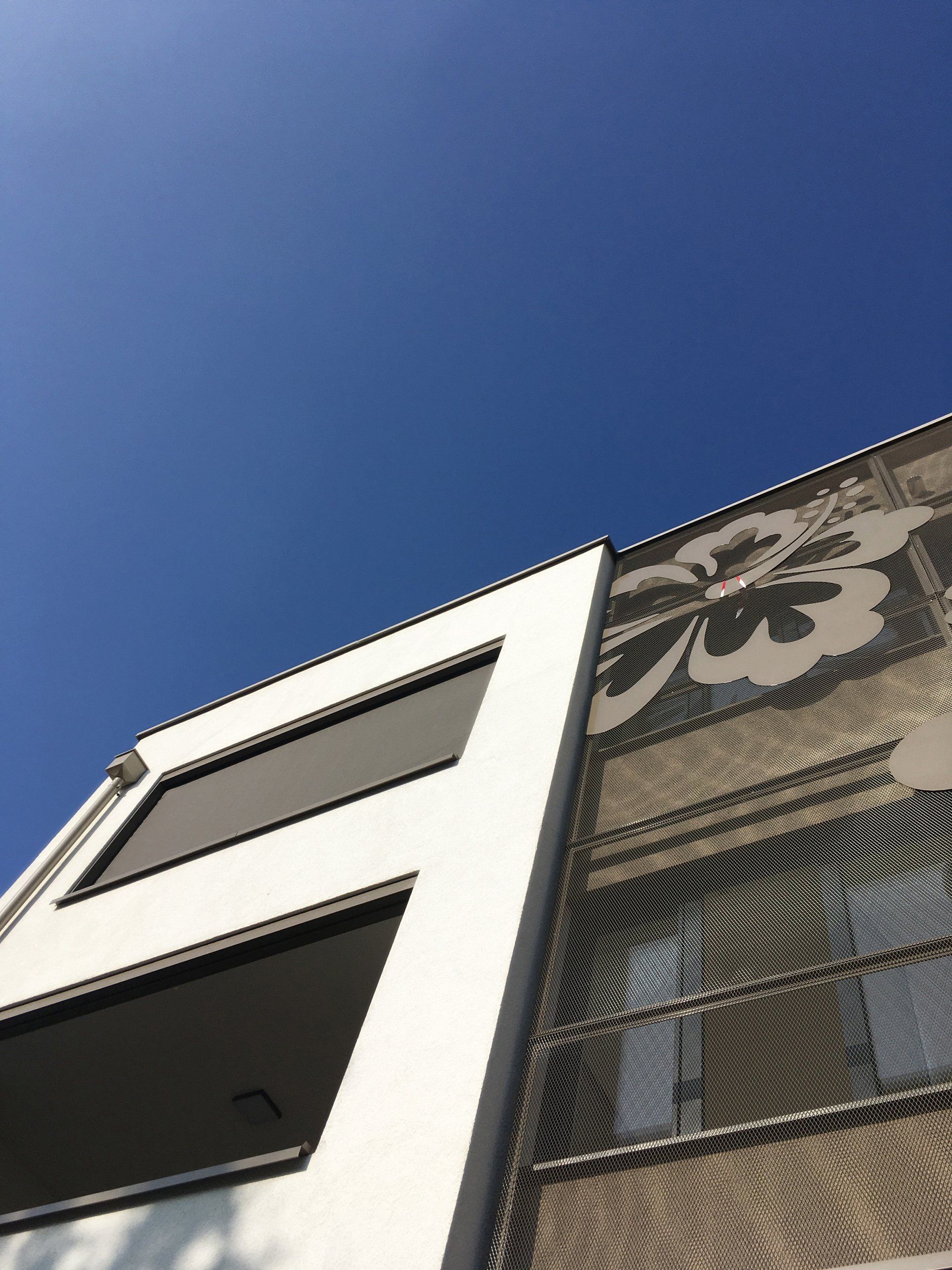 Blick nach oben auf ein Gebäude mit blauem Himmel im Hintergrund
