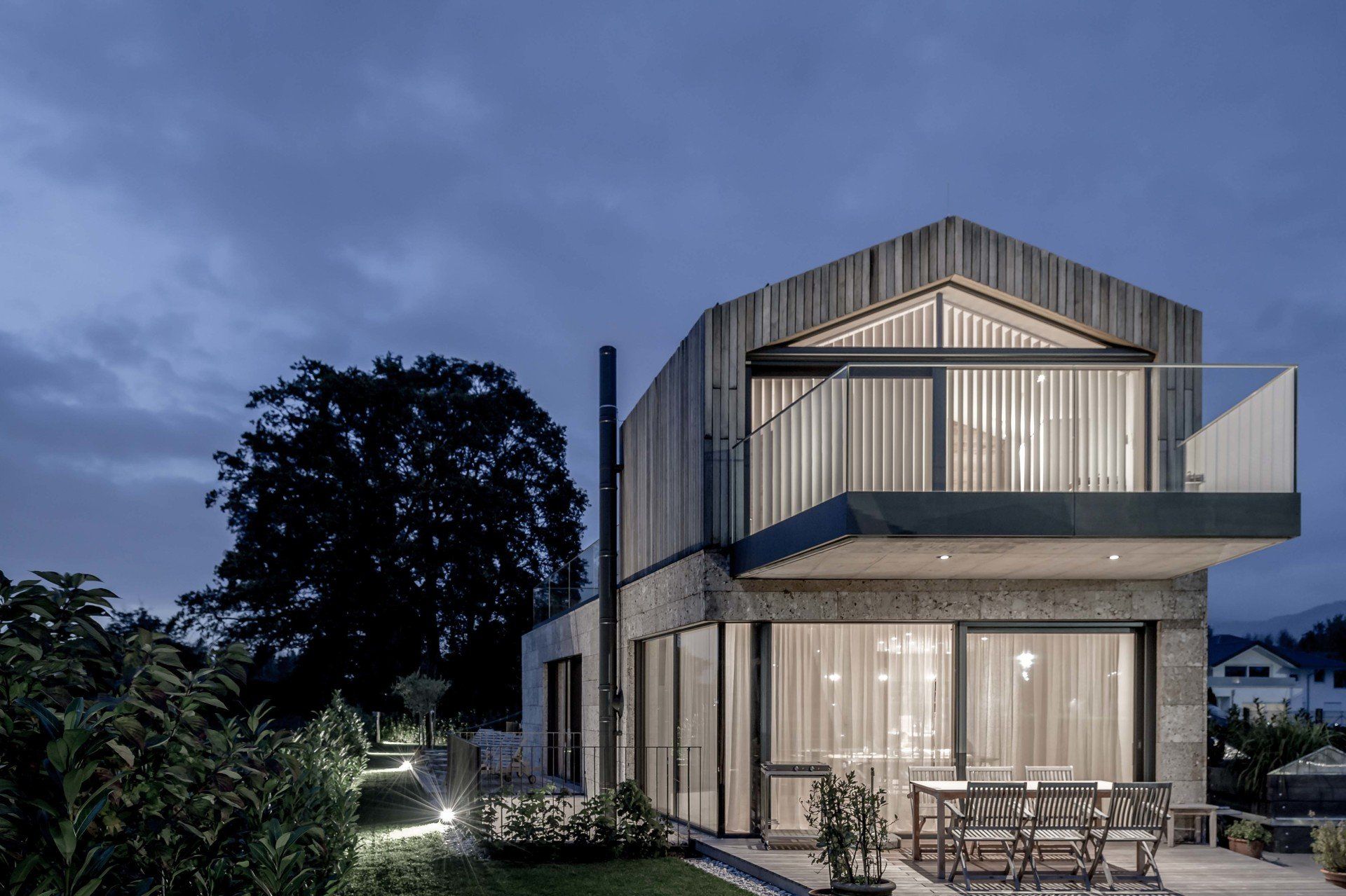 Ein Haus mit Balkon ist nachts beleuchtet