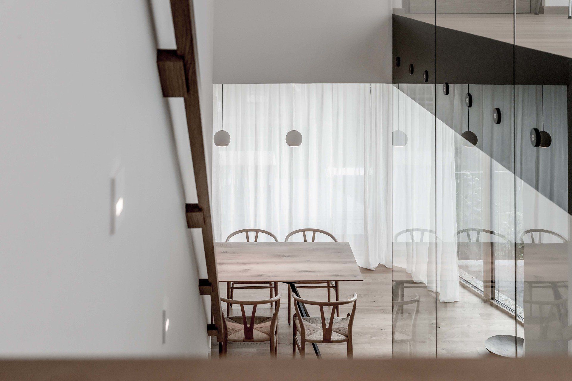 Ein Esszimmer mit Tisch und Stühlen und einem Glasgeländer