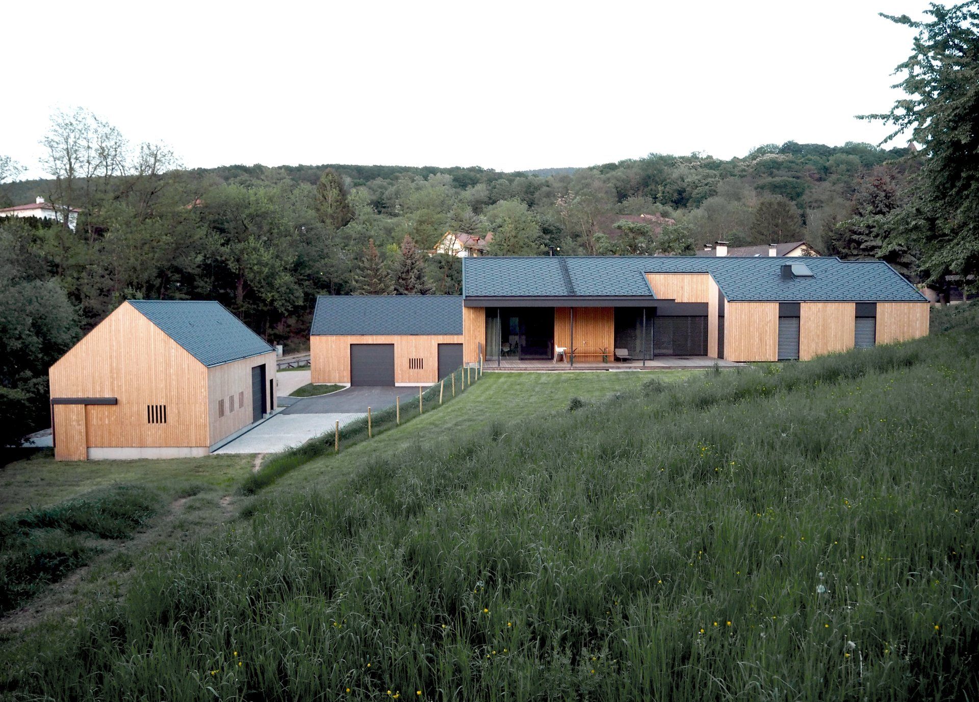 Ein Haus mit blauem Dach steht inmitten einer Wiese