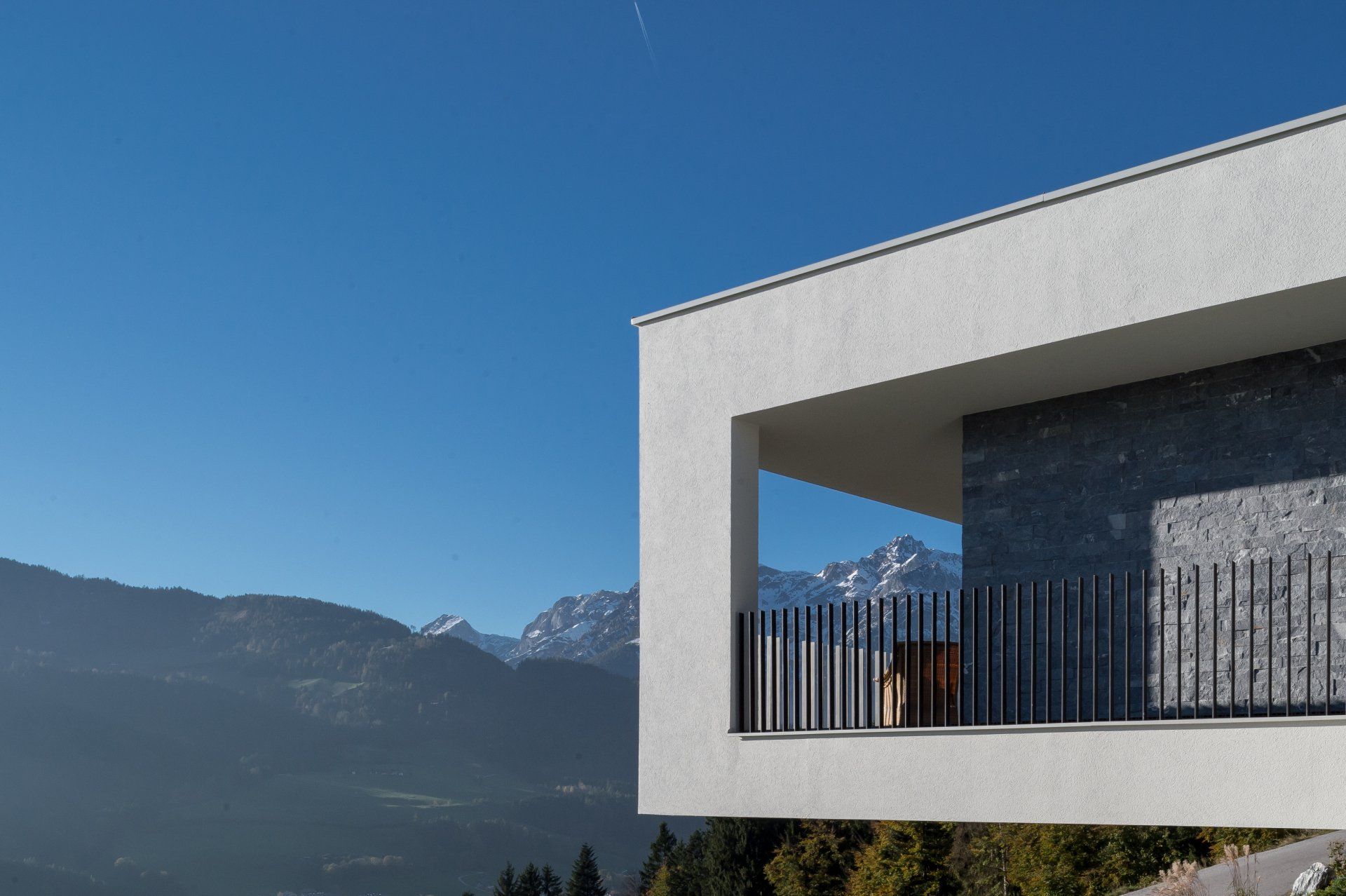Ein Gebäude mit Balkon und Bergen im Hintergrund