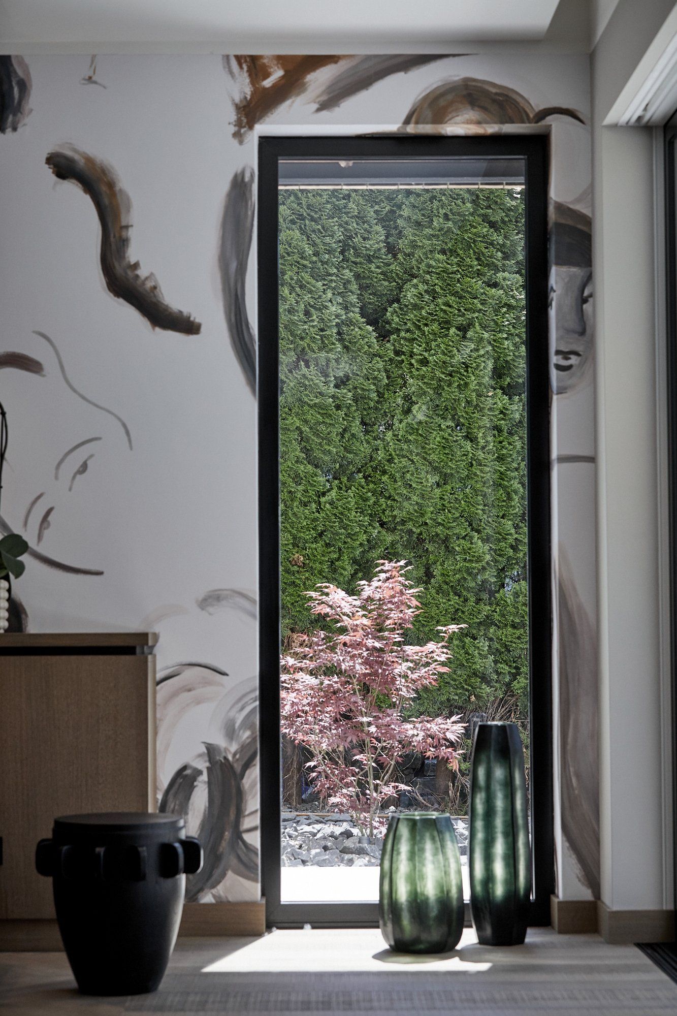 Ein Raum mit einem großen Fenster und einem Gemälde an der Wand.