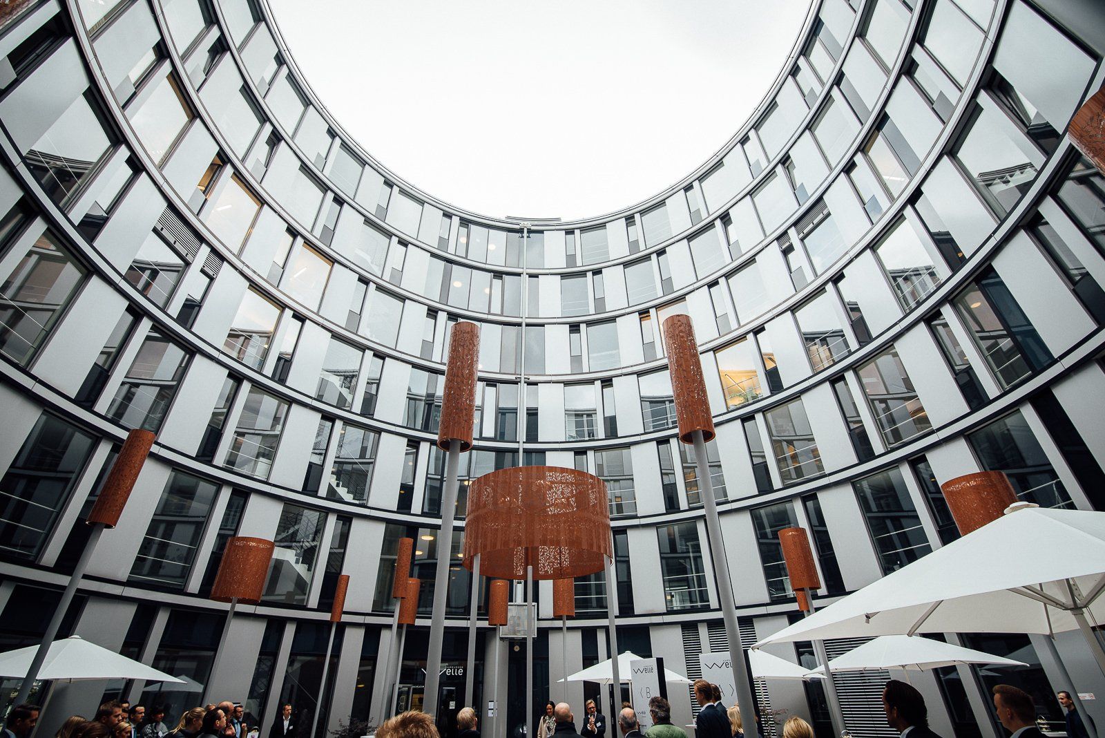 Ein großes Gebäude mit vielen Fenstern und Sonnenschirmen