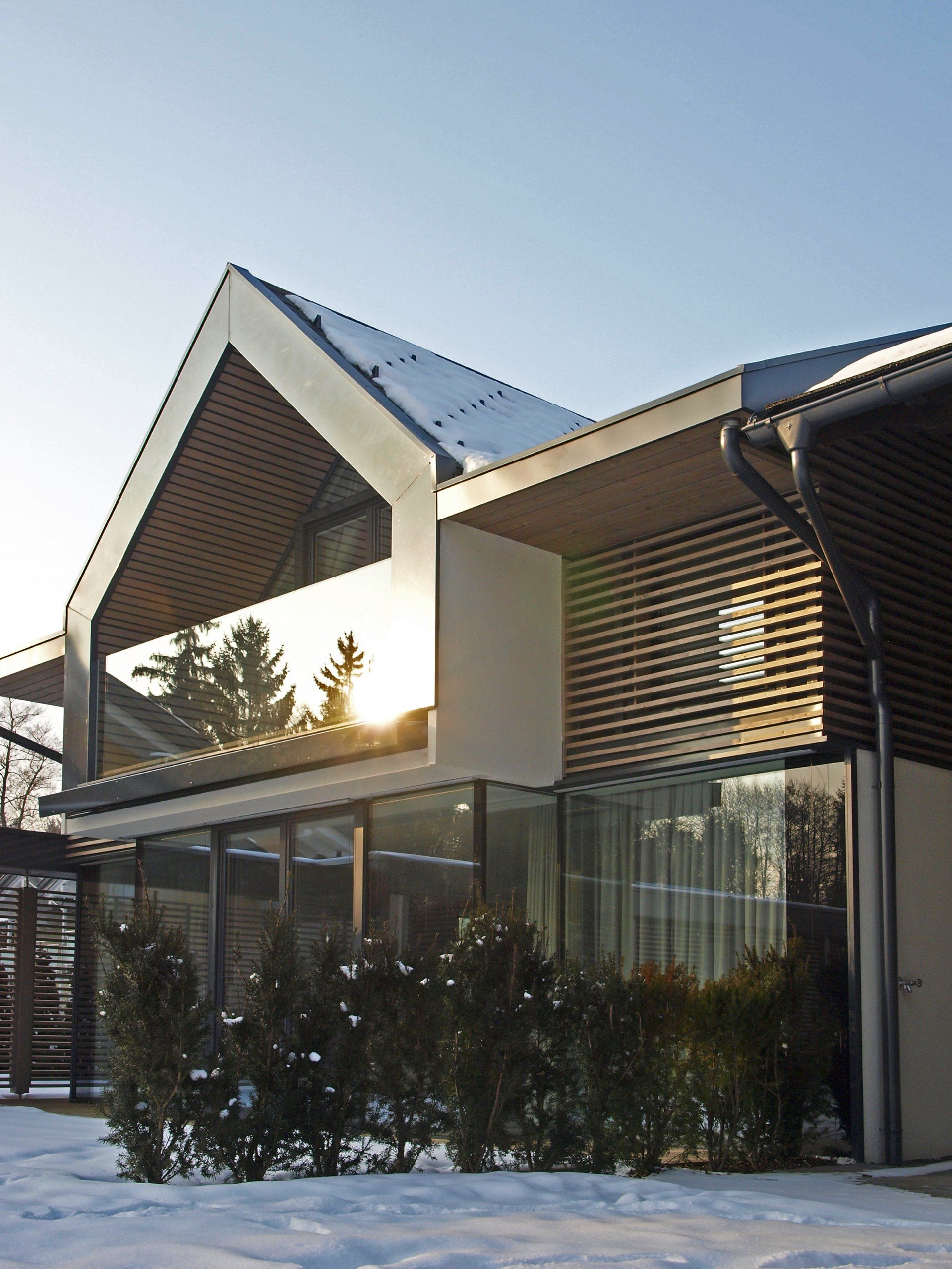 Ein Haus mit einem dreieckigen Dach ist von Schnee umgeben
