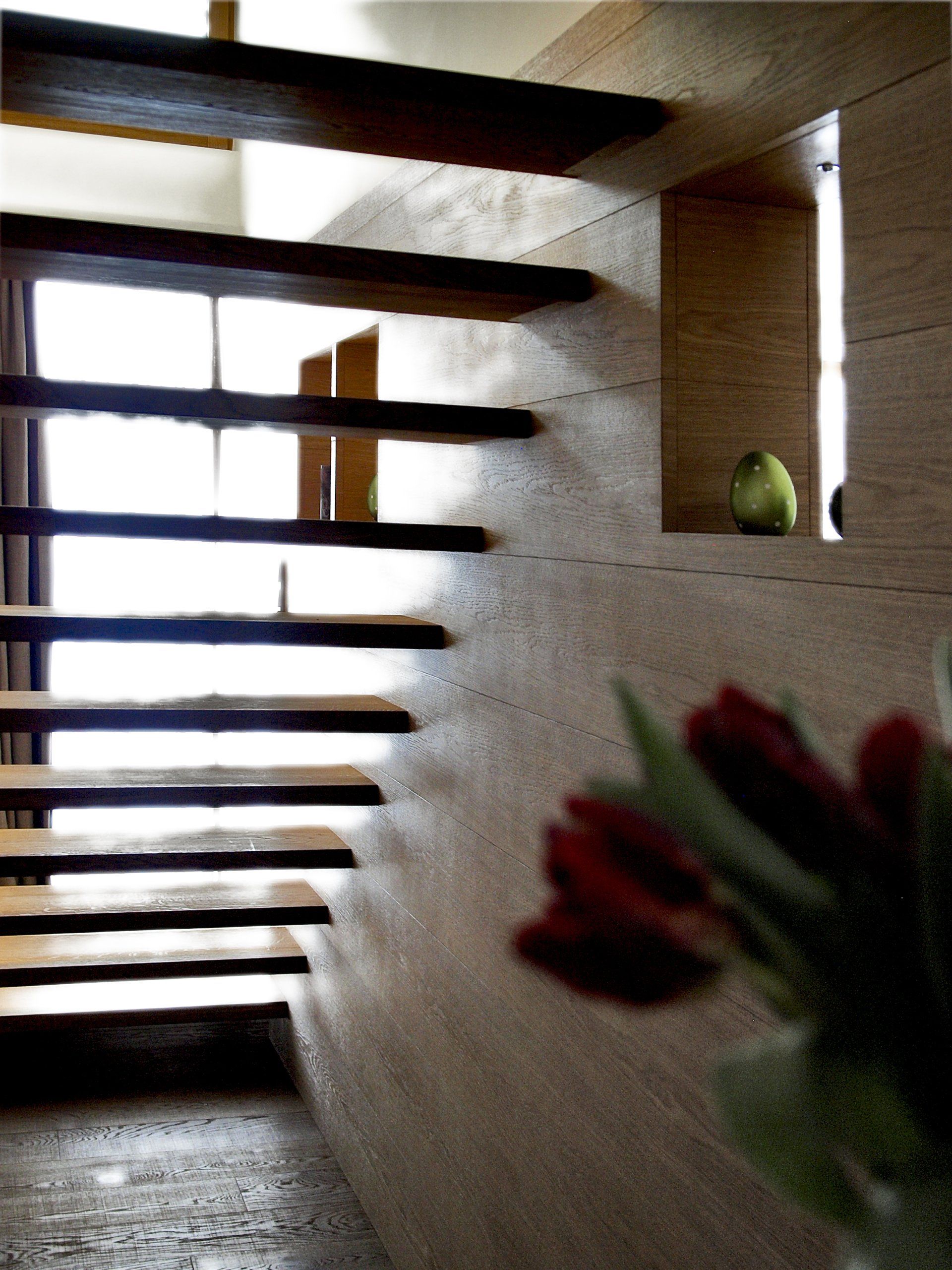 Eine Treppe in einem Haus mit einer Vase mit Blumen im Vordergrund