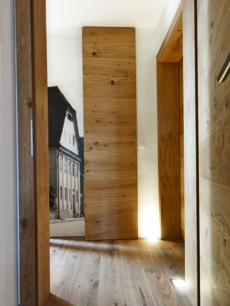 Ein Flur mit einer Holztür und einem Bild eines Hauses an der Wand