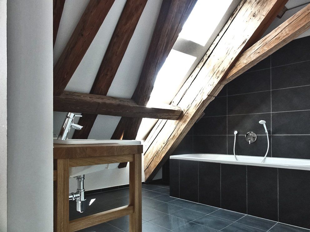 Ein Badezimmer mit Waschbecken und Badewanne unter einem Oberlicht