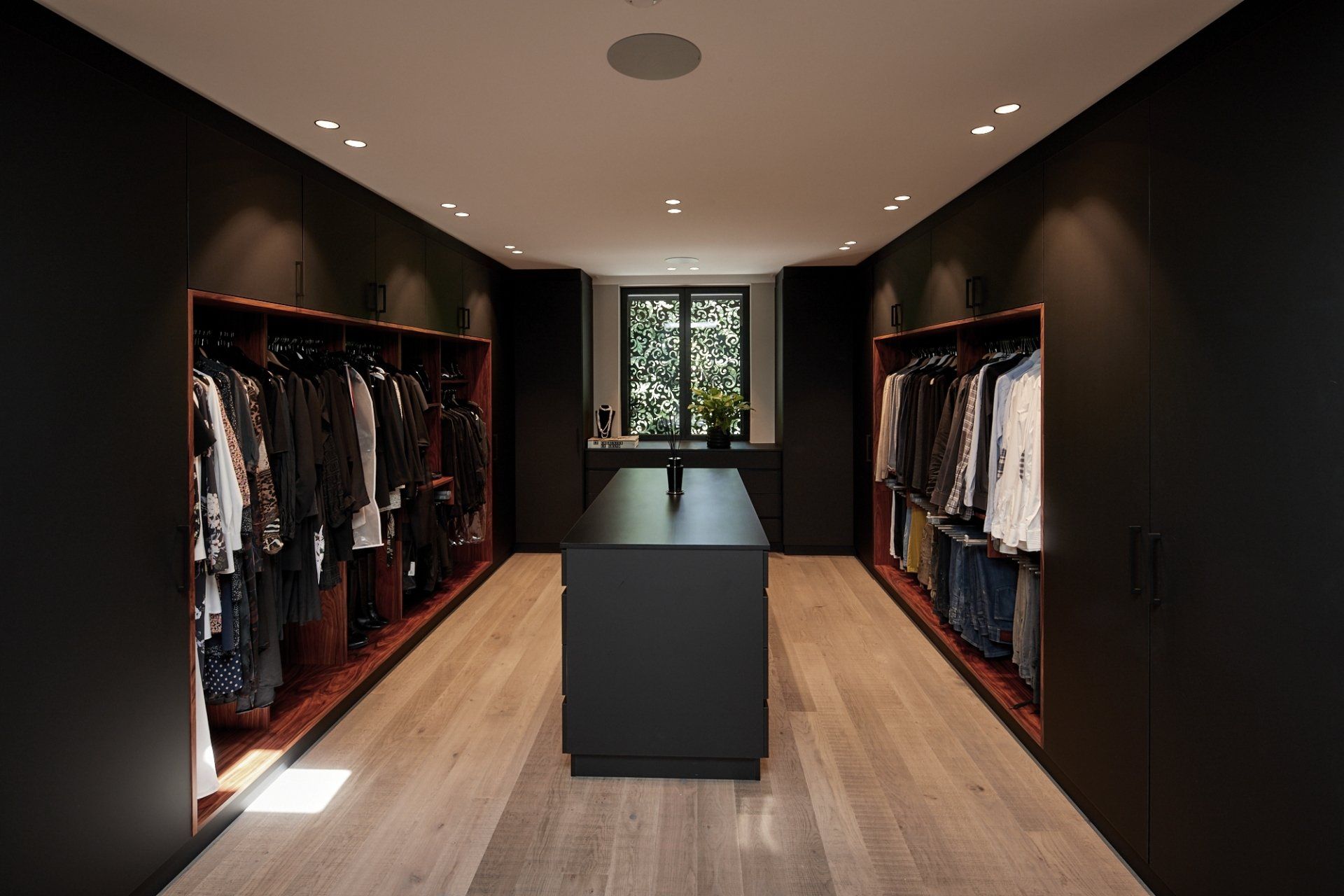 Ein großer begehbarer Kleiderschrank mit einer großen Insel in der Mitte