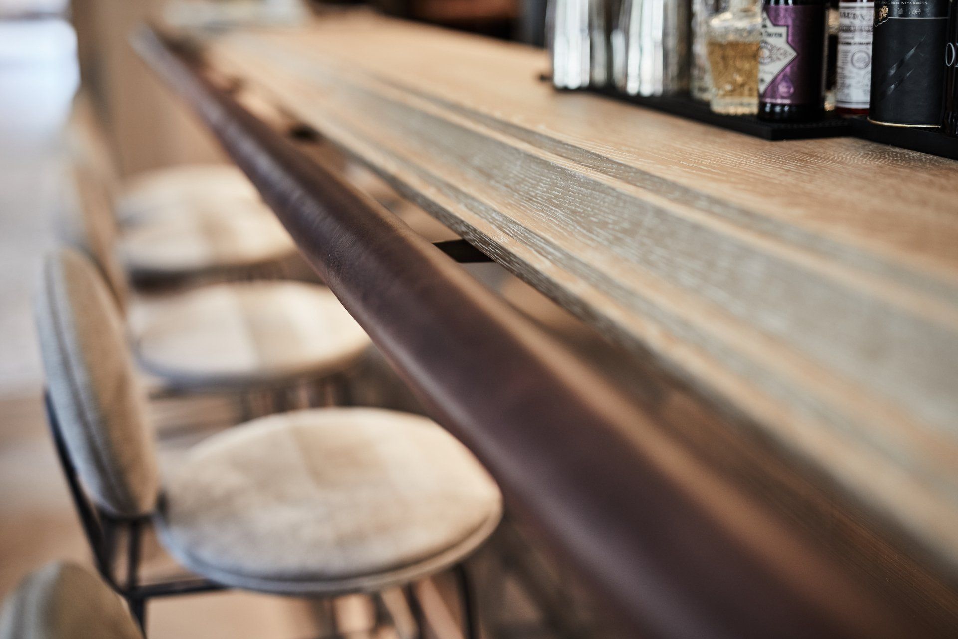 Eine Bar mit Hockern und Alkoholflaschen darauf