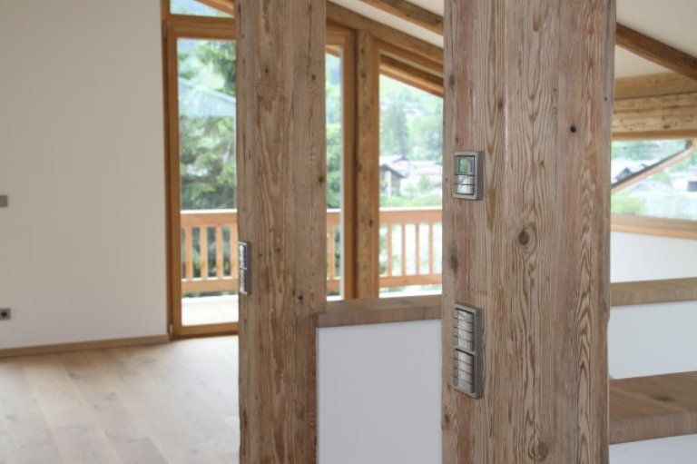 Ein leerer Raum mit Holzsäulen und einem Balkon
