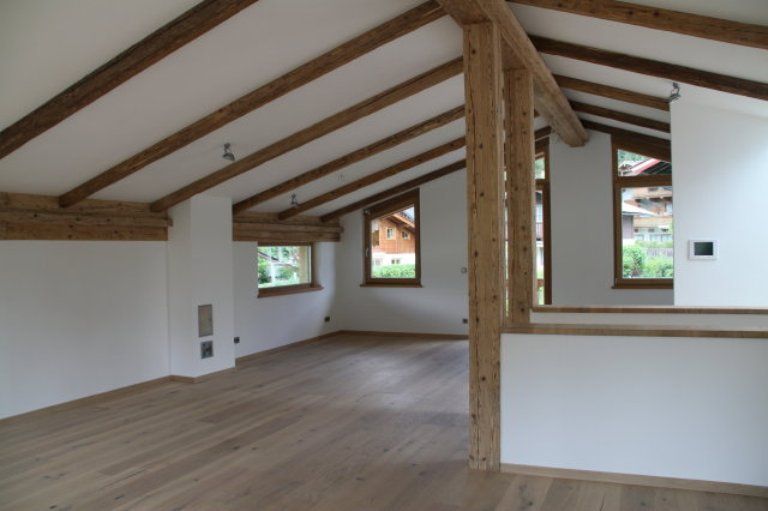 Ein leerer Raum mit Holzbalken und weißen Wänden