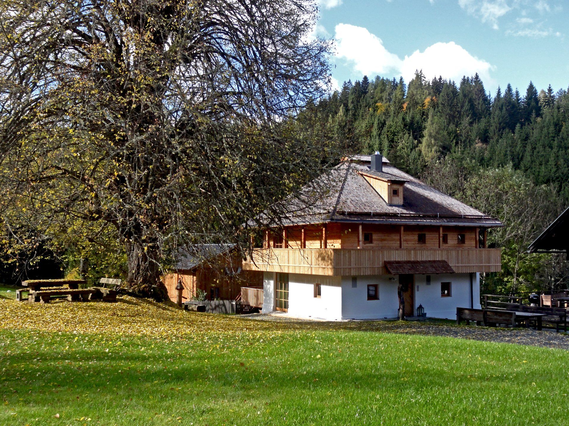 Ein Haus inmitten einer Wiese mit Bäumen im Hintergrund