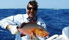 Man holding a fish — darwin fishing tours in Winnellie, NT