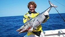 Man holding big fish — darwin fishing tours in Winnellie, NT