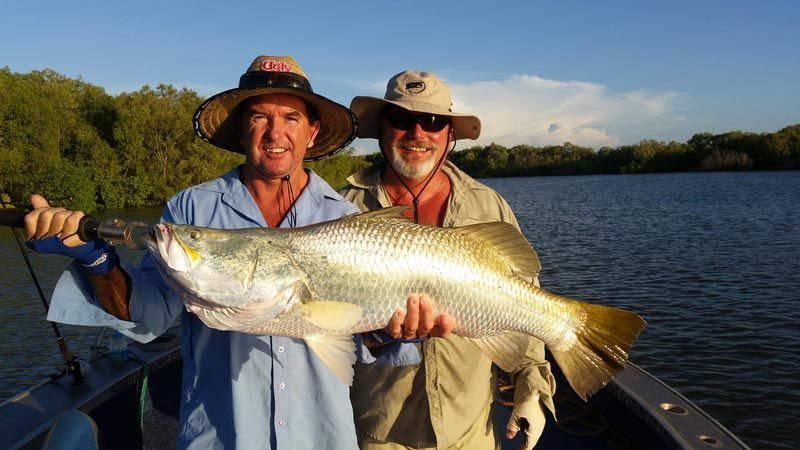 Two men carrying big fish — Barramundi Fishing Darwin in Winnellie, NT