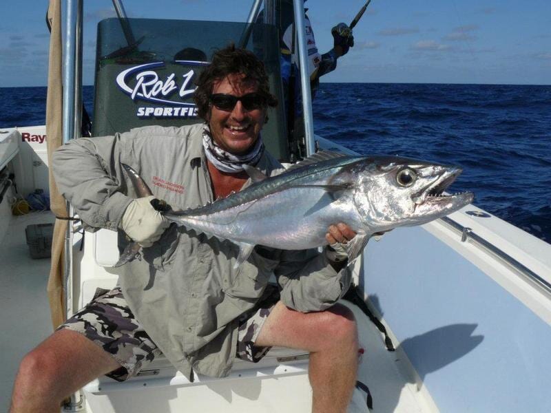 Man carrying big fish in boat — Dean Jackson Guided Tours in Winnellie, NT