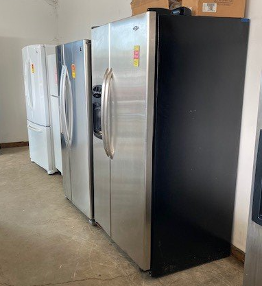 A row of stainless steel refrigerators are lined up in a room.