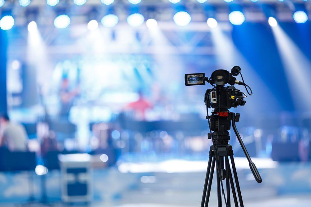 camera on tripod in front of stage