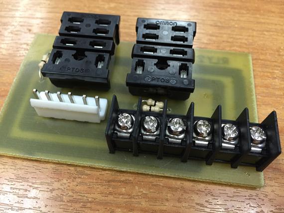 Components on a circuit board: connectors, terminal block, and a white connector with pins.
