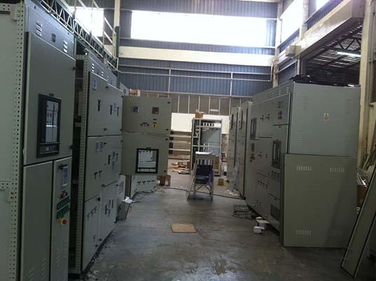 Electrical control panels inside an industrial building; rows of gray cabinets.