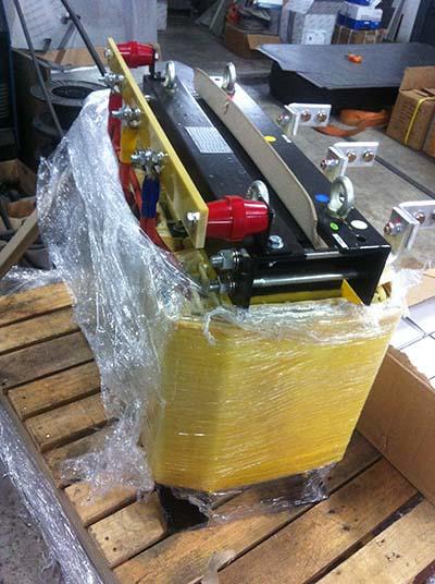 A packaged industrial item, wrapped in plastic, secured to a wooden pallet.