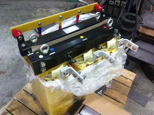 A black and yellow industrial lifting device on a pallet, wrapped in plastic.