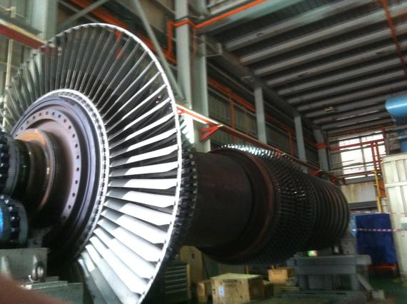 Turbine rotor assembly with blades in a factory setting.