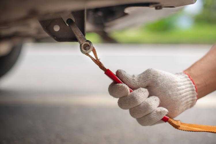 Hand Holding Yellow Car Towing Strap with Car — Haltom City, TX — AA Wrecker Service