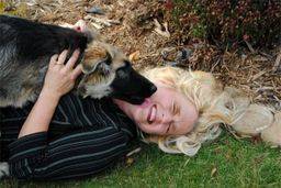 Kimberlee receiving kisses from her dog outside