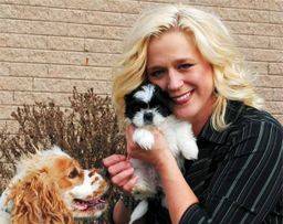 Kimberlee cuddling with a puppy outside