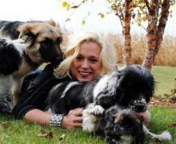 Woman laying down with her dogs outside