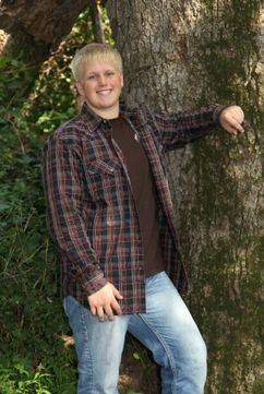 Kimberlee's oldest son, Grant, posing next to a tree for a photo