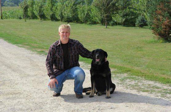 Kimberlee's oldest son posing for a photo in their driveway with his dog