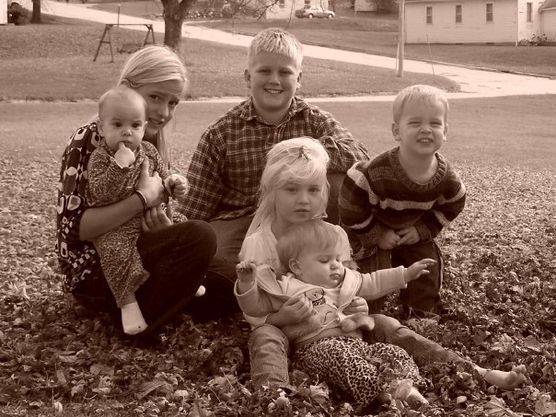 Kimberlee's children posing for a photo in the leaves