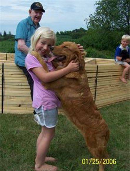 Kimberlee's daughter playing outside with her grandfather, brother, and a golden retriever