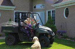 Group of children taking their ranger for a ride on their farm