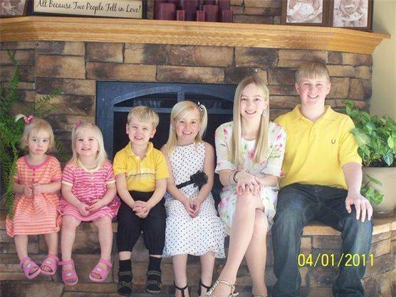 Kimberlee's children sitting in age order for a photo in front of their fireplace