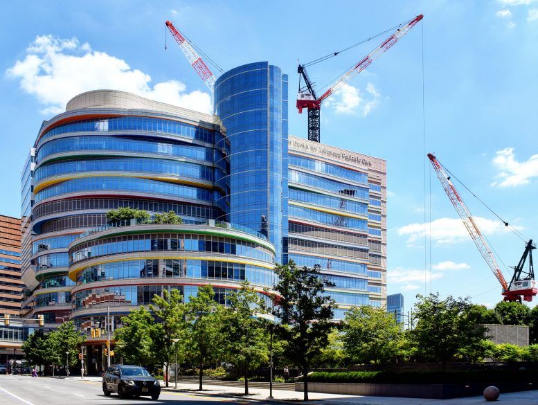 A large building under construction with cranes in front of it